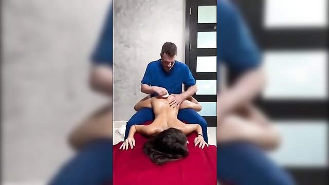 Eva Generosi nude on red bed, massaged intimately by hung stud in blue scrubs