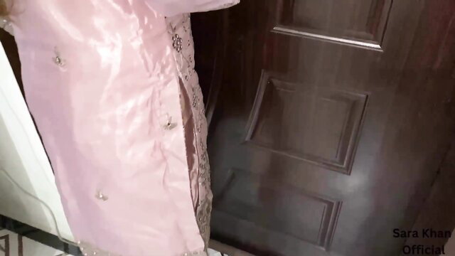 Sara Khan in pink shiny embroidered dress by door, teasing pose