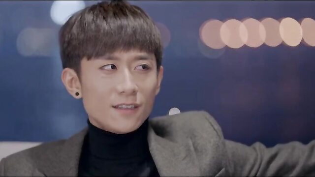 Handsome young Asian man in turtleneck and coat smiling at night bokeh