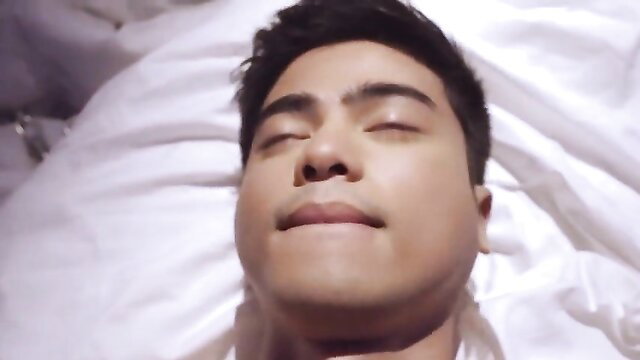 Handsome Asian man lying in bed eyes half-closed lips parted nude tits celebs scene