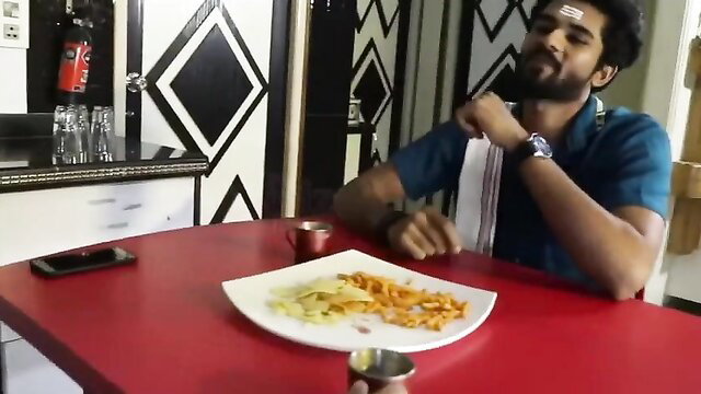 Handsome Tamil Desimedia guy smiling at table with fries
