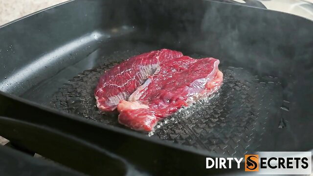 Sizzling raw steak searing on hot grill pan closeup