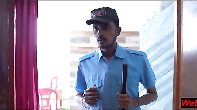 Indian security guard in uniform holds baton in home doorway