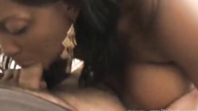 Ebony cougar with XXL tits gives bi-racial blowjob closeup