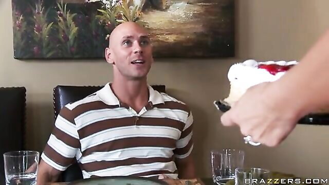 Busty blonde feeds cake to shaved head stud in Milfs Like It Big scene