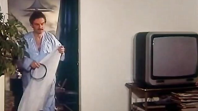 Mature man in robe holding white sheet in bedroom, married woman initiation