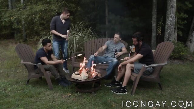 Four hot guys roasting marshmallows by firepit in casual outdoor hangout