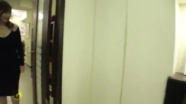 Asian woman in tight black dress walking in hallway