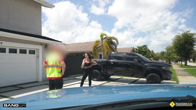Elizabeth Skylar in tight leggings by black truck with safety vest guy