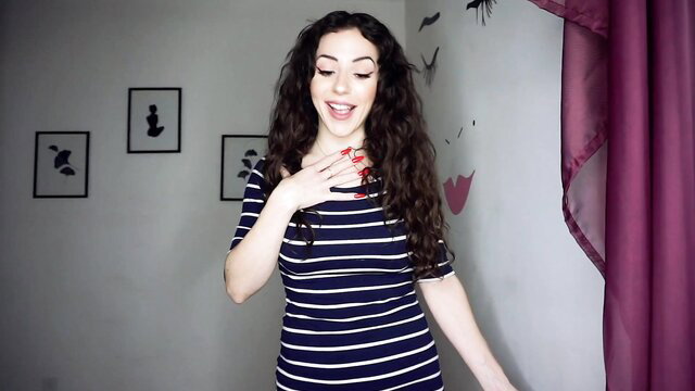 Goddess Fiona in striped dress, smiling seductively, teasing if you're gay
