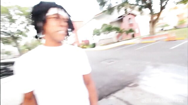 Black man in white tee and shades outside near pink building in Bang the Police porn