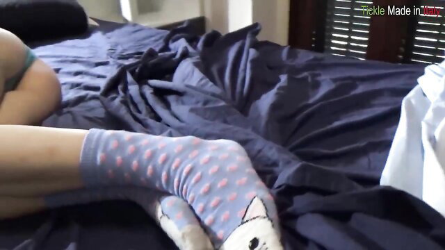 Kelevra in pink polka dot cat socks, sexy legs on bed in TickleMadeInItaly