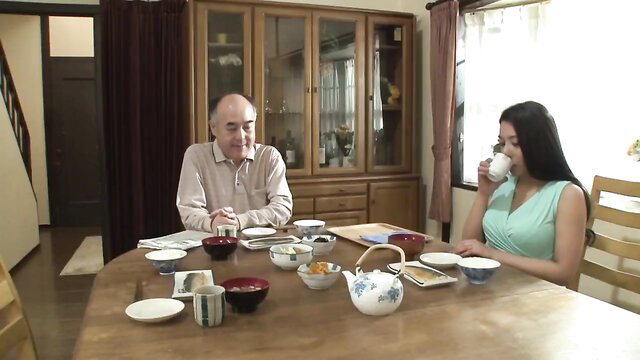 Mei Matsumoto in green dress drinks tea with father-in-law at table JAV