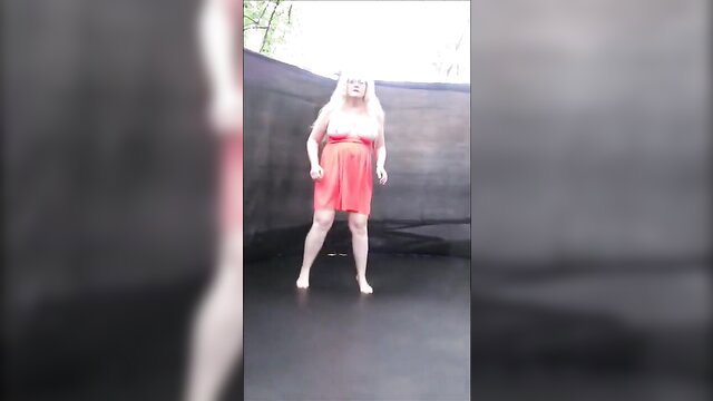 Blonde fat wife bouncing in red dress on trampoline