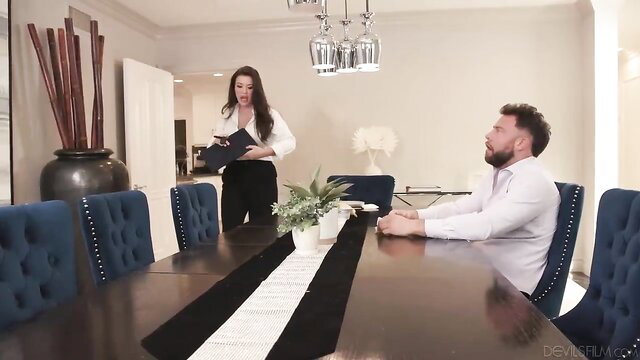 Rissa May in white blouse black pants stands over Elizabeth Skylar at table