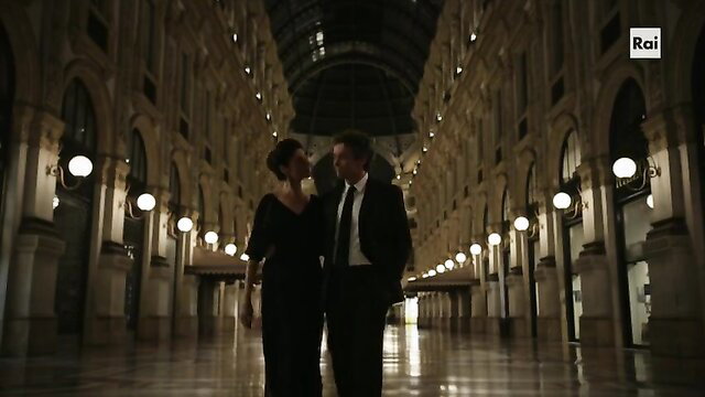 Anna Valle & man in elegant black dress suit couple in grand hall La compagnia del cigno