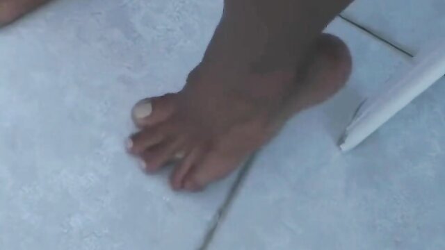 Closeup of Liliana's sexy dark bare feet and toes on tiled floor