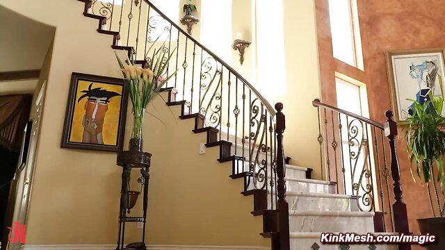 Busty interracial lesbians in luxurious home staircase scene