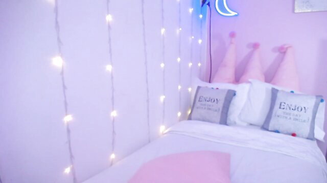 Appetizing webcam MILF in pink bedroom with fairy lights and pillows
