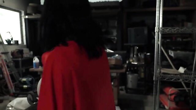 Asian woman in red cape stands in dimly lit room, solo tease