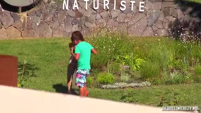 Clothed kids playing outside French naturist resort sign