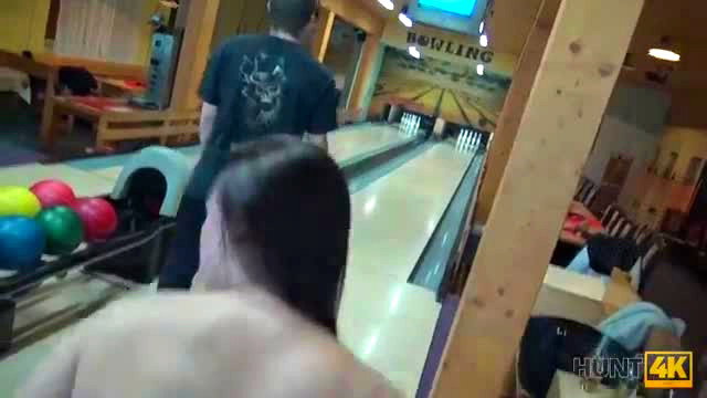 Ornella Morgan bent over bowling lane, guy behind her in black shirt