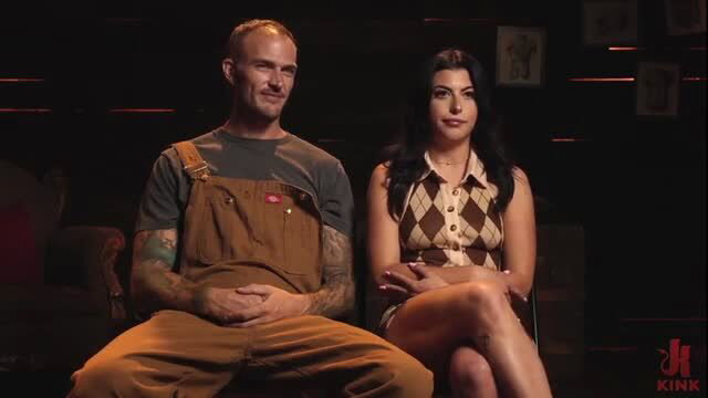 Gal Ritchie with tattooed man in overalls on Kink.com set
