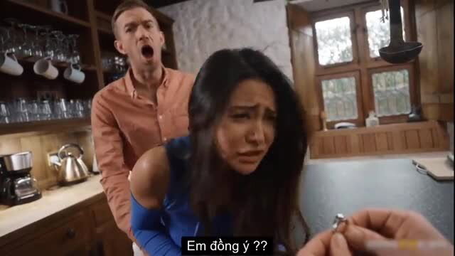 Shocked Asian beauty crying as man proposes ring from behind in kitchen