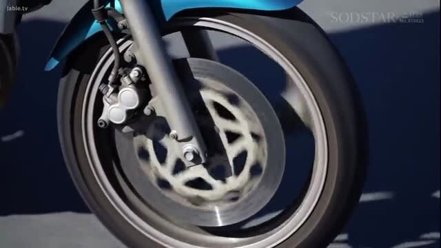 Turquoise sportbike closeup with front wheel, brake caliper visible