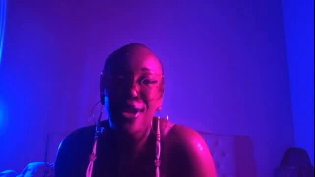 Bald black queen Key smiles wide in neon-lit bedroom tease