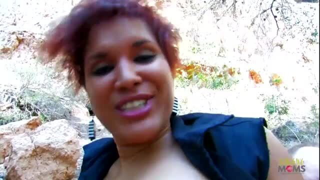 Curvy redhead MILF with black dress in outdoor forest setting