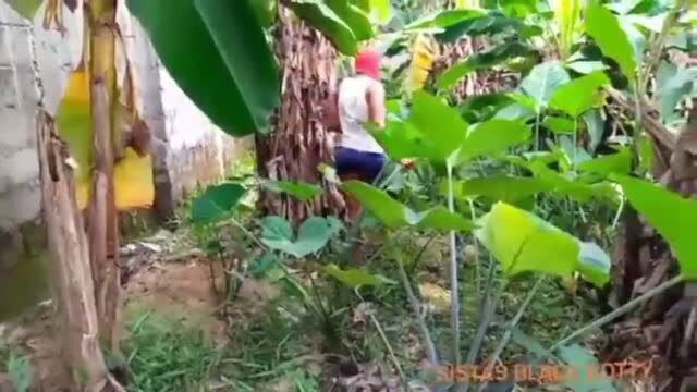 Woman in red cap and black booty shorts walking in jungle path
