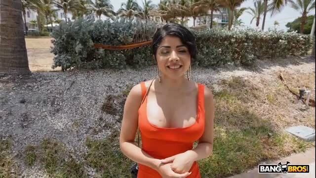 Daya Dare in orange dress, smiling outdoors, Busty Latina model solo