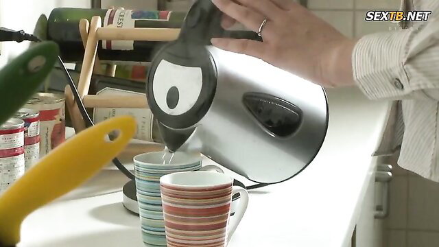 Woman pouring boiling water into cups from kettle in kitchen, Mitani