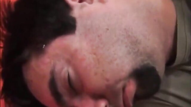 Closeup of bearded man's flushed face in ecstasy, eyes half-closed