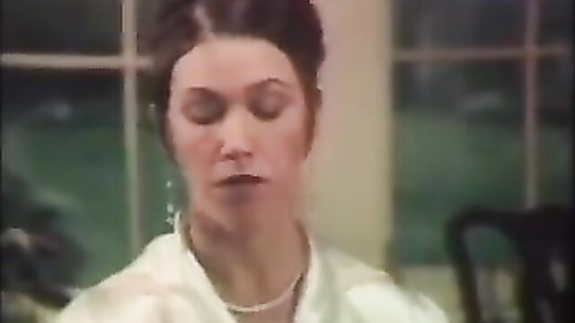 Woman in white top and pearl necklace, eyes closed
