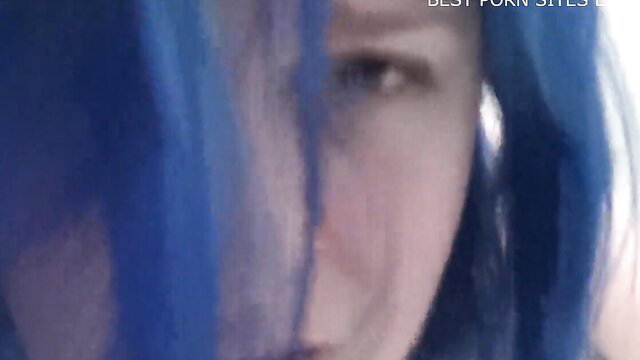 Elle Hell behind blue fabric
