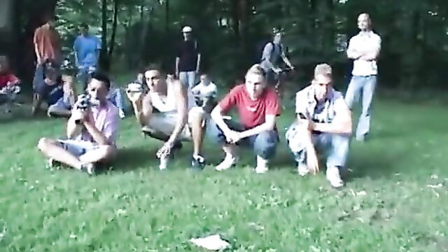 Celia Jones in lesbian parade with group of men squatting outdoors