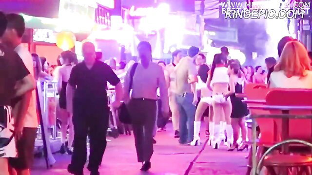 Thai street night scene with sexy women in bikinis and white boots