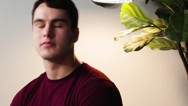 Hot stud Alex meditating in red tee, eyes closed, serene pose