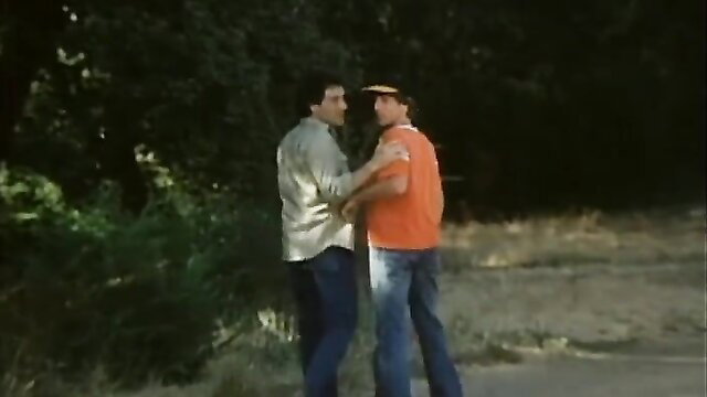 Two men embracing intimately outdoors in classic gay scene