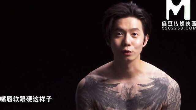 Shirtless Asian man with large chest eagle tattoo closeup