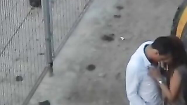 Horny guy embraces cute date passionately outdoors by fence