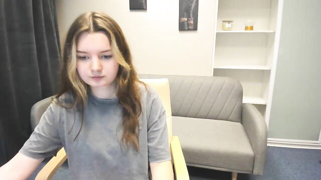 CherryNoir on MyFreeCams, cute teen in grey tee smiling softly