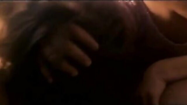Blonde woman in black top gripped passionately in Riptide 2003 scene