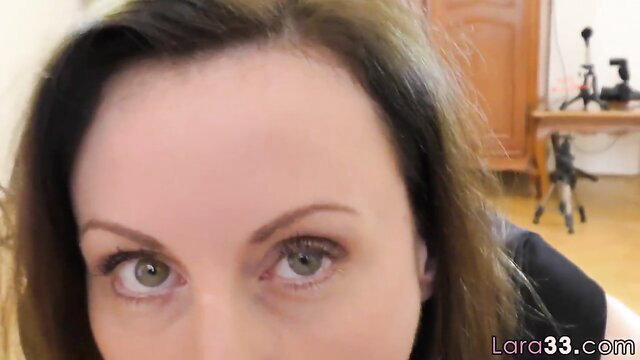 Closeup of mature brunette woman's face with hazel eyes in POV blowjob