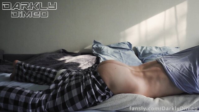 Darkly Dimeo bare back and ass exposed in plaid pants on bed
