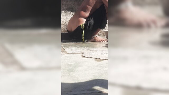 Desi village bhabhi squats in black shorts, flashing ass in open bath
