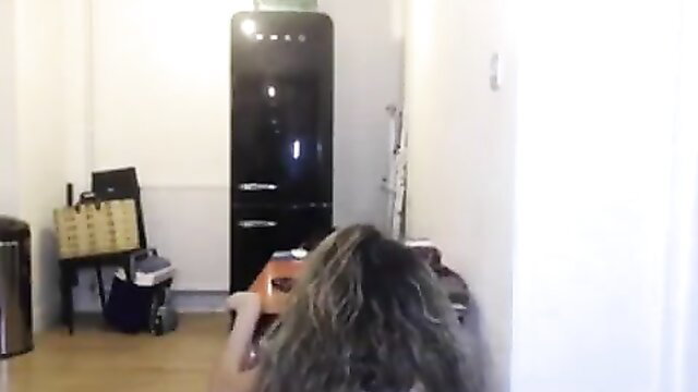 Pregnant woman with gray wavy hair in kitchen before birth