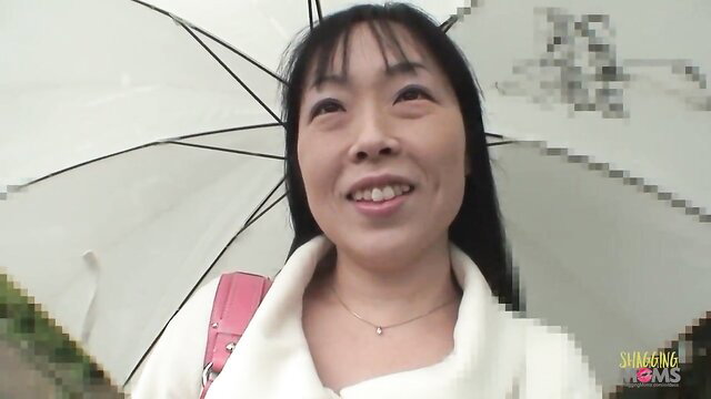 Smiling Asian MILF with bangs under white umbrella, pink bag, white top